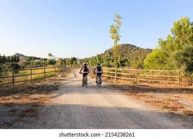 Men Cycling On The Manacor-Arta Greenway, In Mallorca