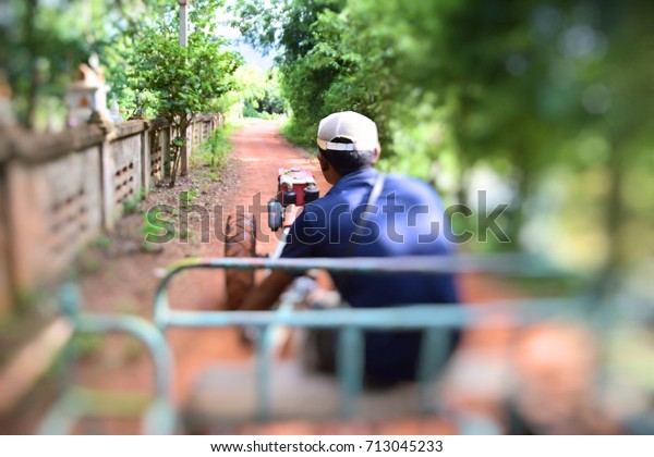 Men are driving a\
vehicle adapted from farm tractor in Thailand. This image was\
blurred or selective focus.