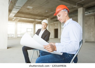 men engineers builders working at the table with a laptop, business negotiations at the construction site. bargain, apartment purchase, real estate