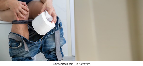 Men Entering The Toilet And Rectal Bleeding Concept, Symptom Of A Serious Disease Such As Colorectal Cancer, Hemorrhoids And Gastrointestinal Bleeding