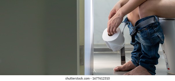 Men Entering The Toilet And Rectal Bleeding Concept, Symptom Of A Serious Disease Such As Colorectal Cancer, Hemorrhoids And Gastrointestinal Bleeding