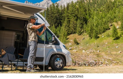 Men Extend and Retract the RV Camper Van Awning. Summer Alpine Campsite Setup. Recreational Vehicles Theme. - Shutterstock ID 2162830965
