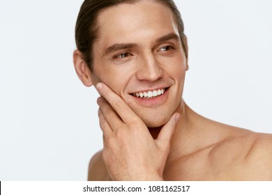 Men Face Care. Man Touching Smooth Skin After Shaving