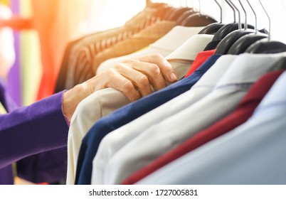 Men Fashion Clothes / Hanging Clothes Suit Colorful Or Closet Rack Different Coloured Man Suits In A Closet On Hangers In A Store Or Showroom