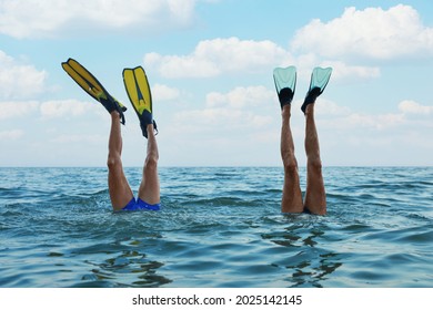 Men in flippers diving into sea water