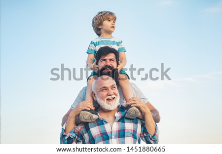 Men generation: grandfather father and grandson are hugging looking at camera and smiling. Fathers day concept. Generation concept. Weekend family play. Men in different ages