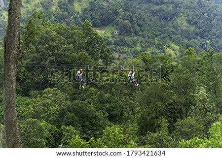 Men going on a zipline in the jungle. tree climbing in Sri Lanka. adventure , challenge and sport concept