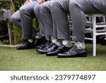 Men in grey suits with plaid green socks and black leather shoes