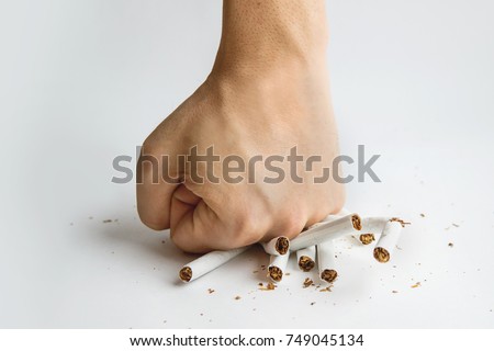 Men hand crushed some cigarettes, No Smoking, Quitting smoking and healthy lifestyle. Guy breaks a cigarette with fingers on white background. The harm of Smoking. To quit Smoking.