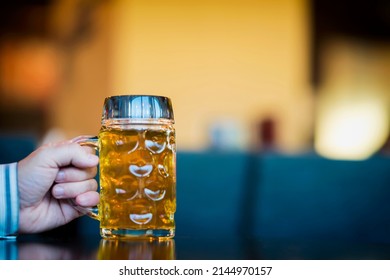 Men Hand With Glass Mug Of Golden Freshly Filled Beer. Real Scene In Bar, Pub. Beer Culture, Craft Brewery, Uniqueness Beer Grades, Meeting Of Low Alcohol Beverage Lovers. Copy Space