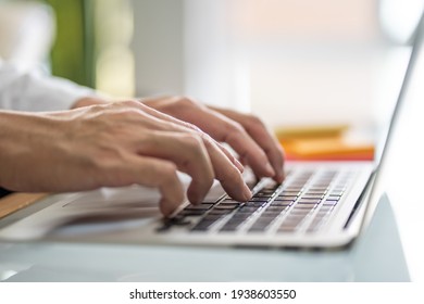 Men hand typing on computer keyboard while working from home or using internet for online shopping and social network. Laptop device and Wireless technology concept.  - Shutterstock ID 1938603550