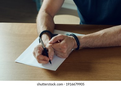 Men Hands With Handcuffs Fill The Police Record, Confession. On Top Of The Police Investigative Detective. Arrest, Bail, Criminal, Prison. Fingerprints, Criminal