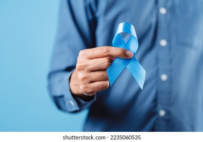 men hands showing Blue ribbon for supporting people living and illness, Colon cancer, Colorectal cancer, Child Abuse awareness, world diabetes day, International Men's Day - Powered by Shutterstock