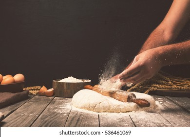 Men hands sprinkle a dough with flour close up. Man preparing bread dough - Powered by Shutterstock