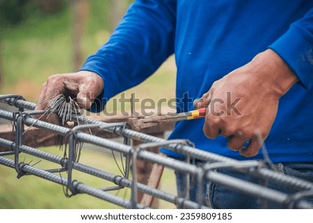 Men hands using pincer pliers iron wire reinforcement of concrete work. Construction Worker hands bending cutting steel wire fences bar. Outdoor Worker using wire bending pliers, construction work.
