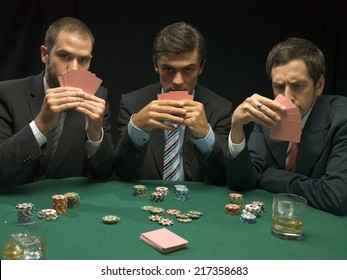 Men holding playing cards at poker game