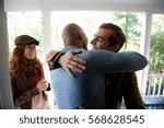 Men hugging at front door