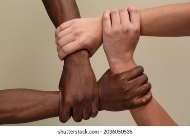 Men joining hands together on beige background, closeup - Shutterstock ID 2036050535