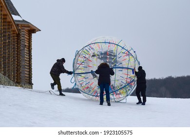 Men launch zorbing into action. Safari Park Kudykin mountain. Lipetsk region. Russia. January 2021