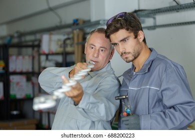 Men looking down the length of a threaded bar - Powered by Shutterstock