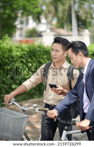 Men lost in city checking map on smartphone to find shorter road to ride to destination