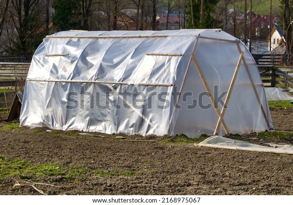 A men made greenhouse for planting vegetable and\
fruit in winter. Preparing for food shortage by being self\
sufficient and growing organic food. An off grid farm. A hothouse\
in the country. Crops.