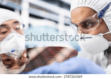 Men in microchip manufacturing plant inspecting high tech semiconductor substrate components, teamworking engineers in silicon wafer factory cleanroom verifying optical lithography patterns.