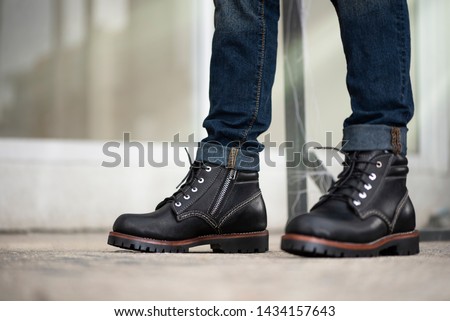 The men model wearing jeans and black boots leather with zipper for man collection.