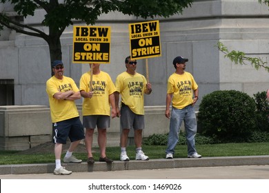 Men On Picket Line In Yellow Shirts With Signs