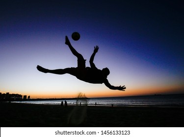 Men Play Footvolley In The Sunset