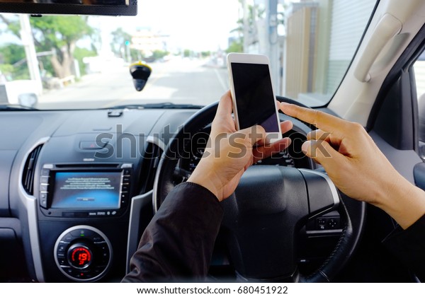Men play phones in cars\
when driving.