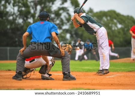 Men playing baseball game. Batter getting ready to hit a pitch during ballgame on a baseball diamond, field.