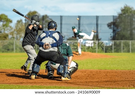 Men playing baseball game. Batter trying to hit a pitch during ballgame on a baseball diamond, field.