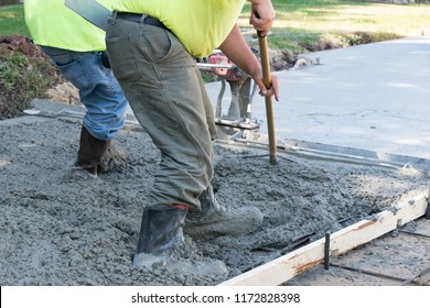 Men Pouring and Finishing a Concrete Slab Driveway with a Wet Cement Mix - Shutterstock ID 1172828398