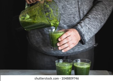 Men pouring some fresh homemade green juice in a glasses healthy food weight loss fitness food concept - Powered by Shutterstock