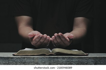 Men pray from god blessing to have a better life. Christian Crisis Prayer to God.  Men's hands praying to God with the Bible.  believe in good  Hold hands in prayer on a wooden table. - Shutterstock ID 2185948389