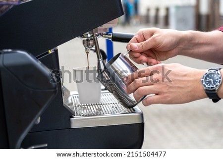 men preparing cup of coffee on the street, handsome barista man during work in his movable street coffee shop