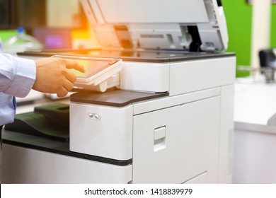 Men press the button of the copier. Man copying paper from Photocopier. Men use printing machines. The concept of using a copier or paper printer.