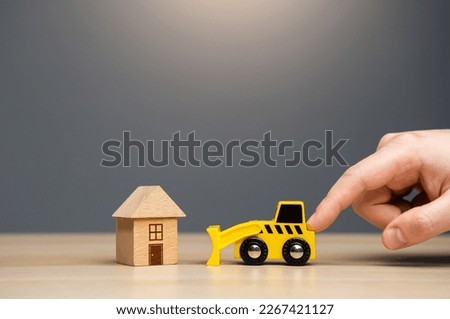 Men pushing gives the order to the bulldozer to demolish the house. Encroachment on private property. Illegal buildings construction. Plan for the renewal and restoration of residential areas. Lawsuit