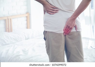 Men Put Their Hands On The Buttocks. Have Anal Pain.The Man Stands In A White Room. Handles The Buttocks For Abdominal Pain.