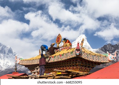 Men renovating old gates of the buddhist Tengboche Monastery, also known as Dawa Choling Gompa and the Ama Dablam mount in the background, Everest Base Camp Trek, Sagarmatha National Park, Nepal.  - Shutterstock ID 668255095