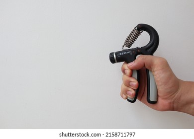 Men right hand squeeze the muscle training grip. Hands grip strengthening tools.  - Shutterstock ID 2158711797