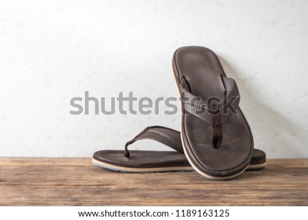Men sandals footware brown on wood grunge table desk with copy space.