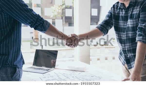 Men shake hands after the deal is done,\
Architects and engineers join hands to congratulate them after the\
building site meeting is completed, Symbol of friendship in\
business of both parties.