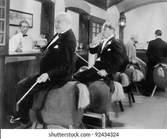 Men sitting at a bar on horse back