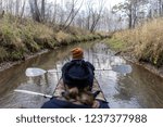 Men sitting in an inflatable boat and rowing oars, floating on the river in the woods