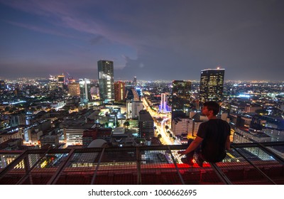 Men Sitting On The Rooftop Mexico City With Night Downtown View. Mexico City Skyline At Night From Top