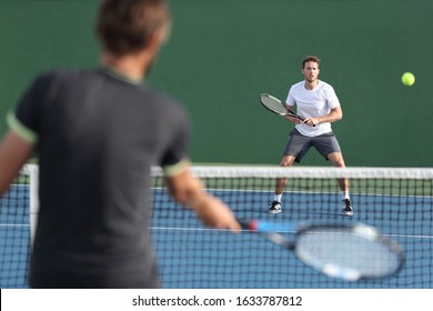 Men sport athletes players playing tennis match together. Two professional tennis players hitting ball on hard outdoor court during game. - Powered by Shutterstock