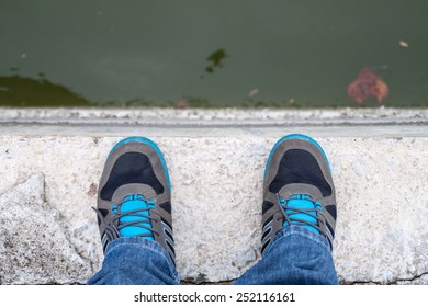 A men standing on the edge of a bridge. First person view.