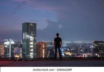 Men Standing On The Rooftop Mexico City With Night Downtown View. Mexico City Skyline At Night From Top